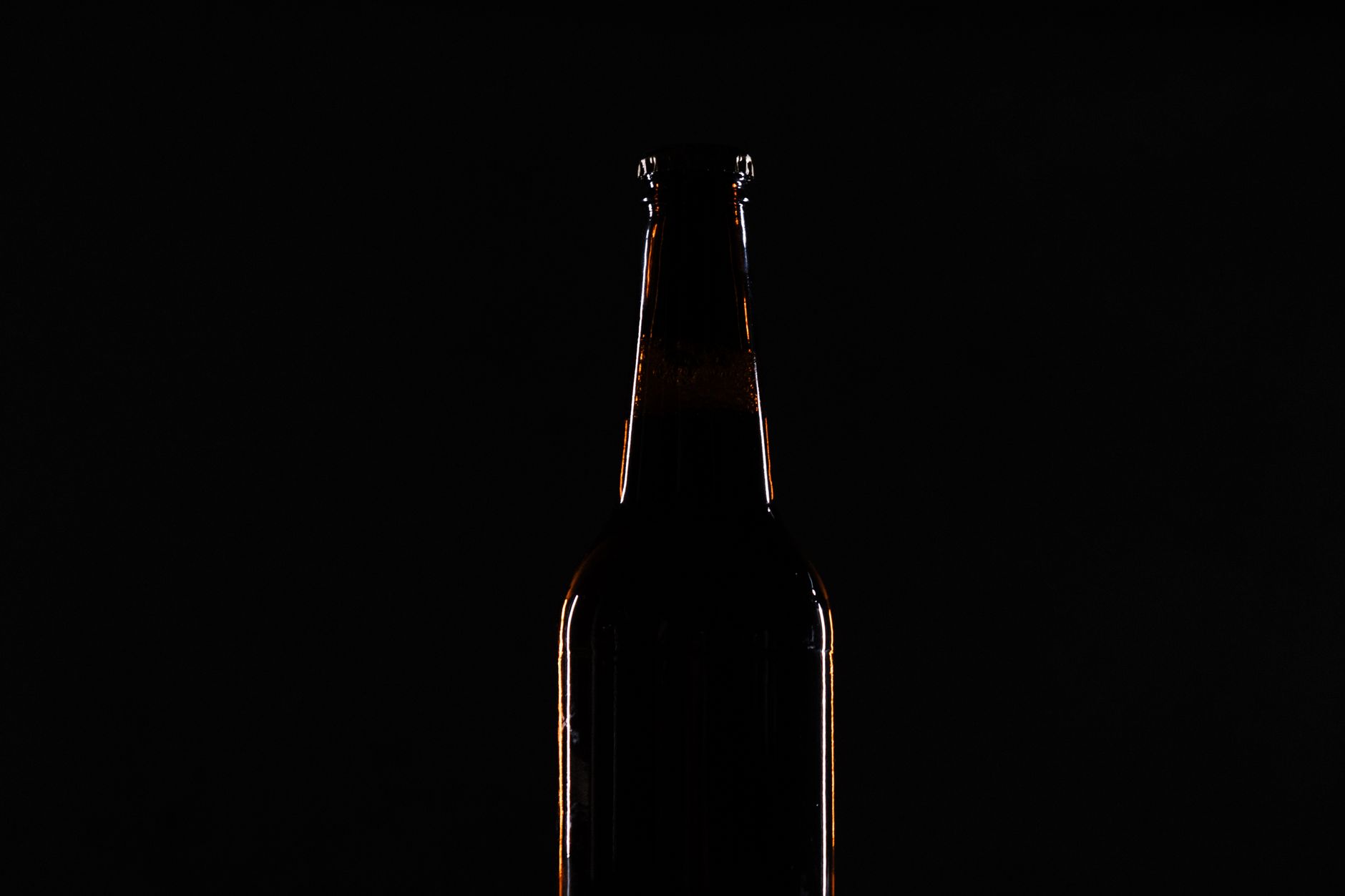 A bottle outlined by rim light on a black background