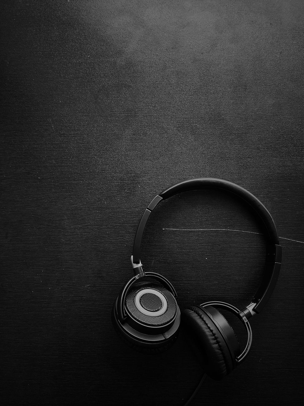 Headphones lying on a dark textured surface