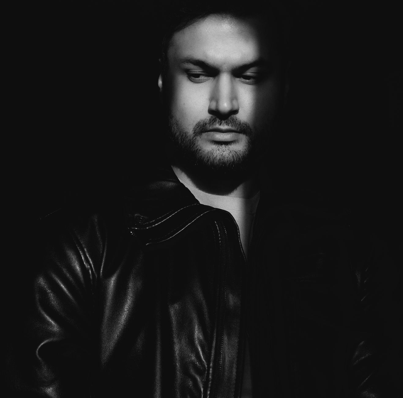 A man in a leather jacket, his face half in shadow