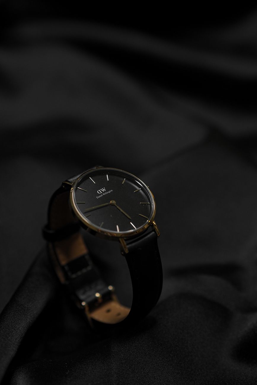 A black wristwatch on dark fabric
